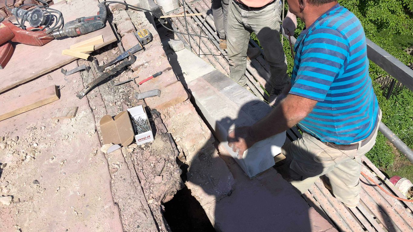Construction workers on scaffolding with tools and materials.