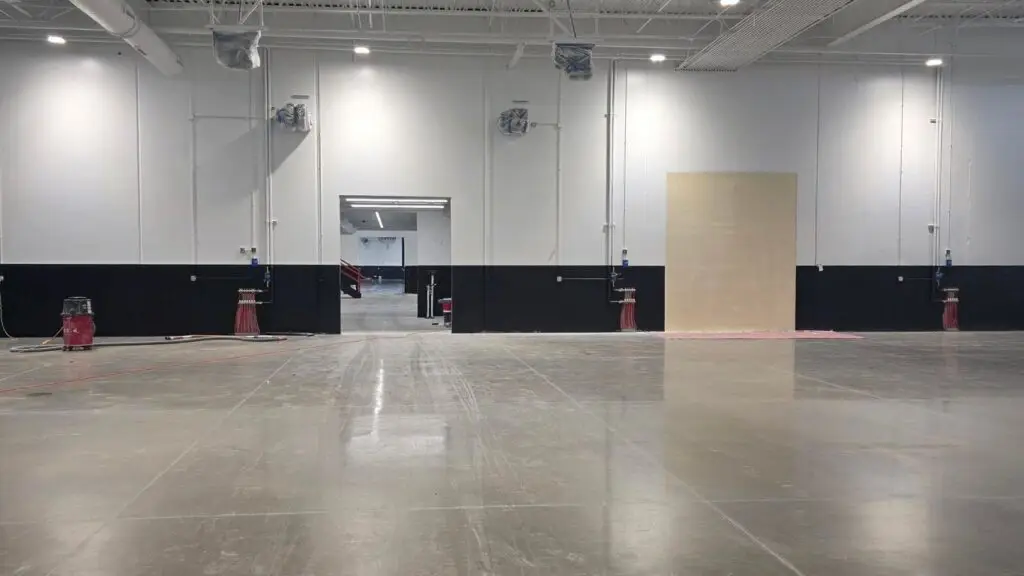 Large empty indoor space with concrete floor and exposed ceiling ready for a lighting contractor in Chicago