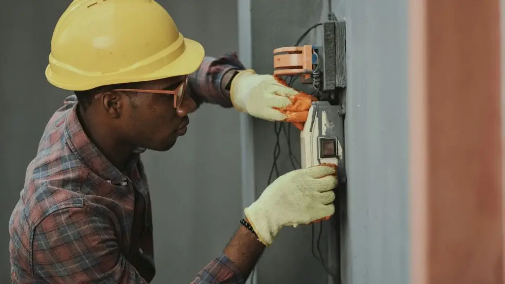 man in brown hat holding black and gray power tool