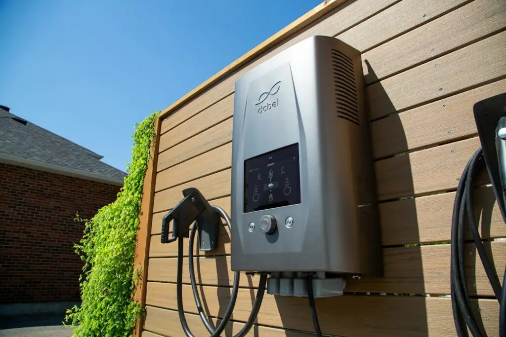 Professional electrician installing a wall-mounted Level 2 EV charger in a modern garage - ev charger home installation