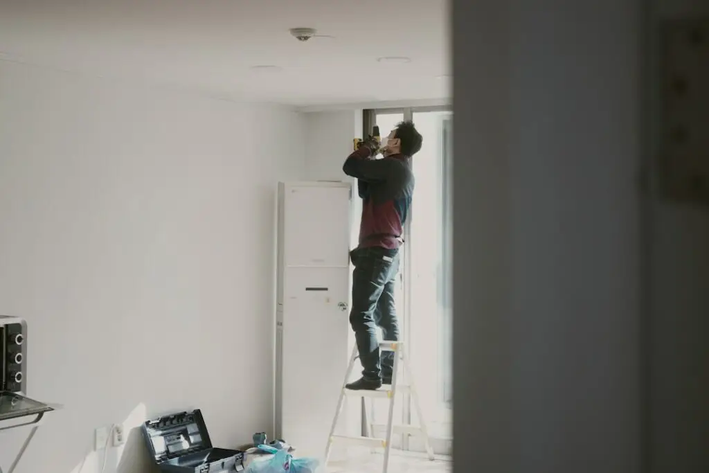 Electrician installing an LED retrofit downlight into an existing ceiling can